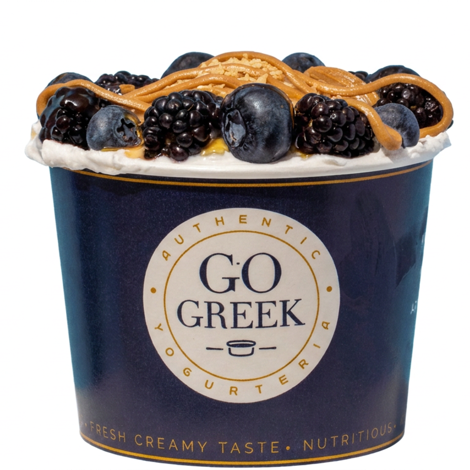 Go Greek yogurt cup topped with blackberries, blueberries, and golden honey drizzle.